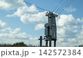 A transformer shed in a field on a sunny day. 142572384