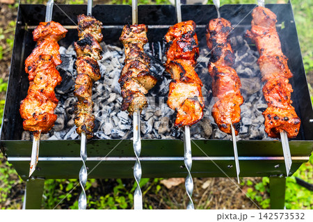 colorful shish kebabs on steel skewers on mangal 142573532