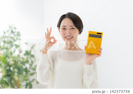 電卓を持つ女性	 142573739