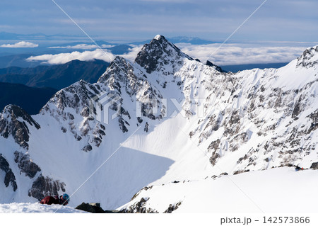 北穂高岳の山頂から見る朝日に輝く前穂高岳　初夏残雪期の北アルプス北穂高岳登山 142573866