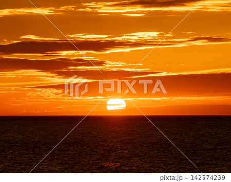 海に沈む夕日とオレンジ空 142574239