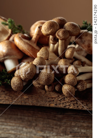 An assortment of mushrooms on a rustic wooden board with sprigs of thyme. An assortment of mushrooms on a rustic wooden board with sprigs of thyme. 142574290