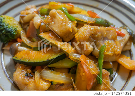 彩り豊かな野菜と鶏肉を香ばしく炒めた家庭料理 142574351