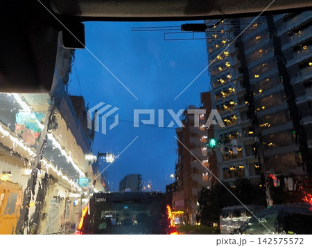 ​激しい雨の車内から見上げるビル群と黄昏時の青空 142575572