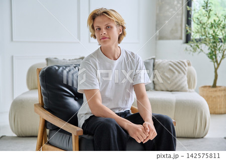 Serious teenager student sitting in armchair indoor 142575811