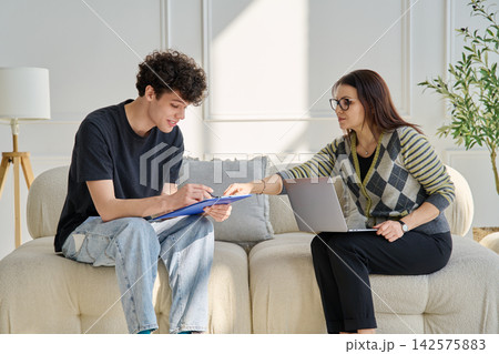 Young male patient in therapy session talking with female psychotherapist Young male patient in therapy session talking with female psychotherapist 142575883
