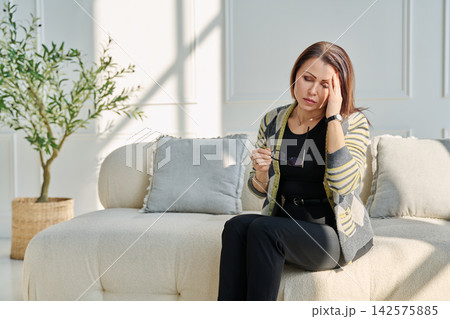 Mature sad woman experiencing stress, mental and physical pain, at home Mature sad woman experiencing stress, mental and physical pain, at home 142575885