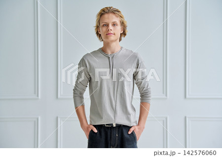 Handsome teenage boy with hands in pockets indoors 142576060