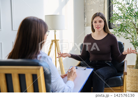 Young woman patient in therapy session talking with female psychotherapist Young woman patient in therapy session talking with female psychotherapist 142576130