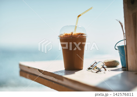 Close-up of a refreshing iced coffee in a plastic cup with a straw Close-up of a refreshing iced coffee in a plastic cup with a straw 142576811