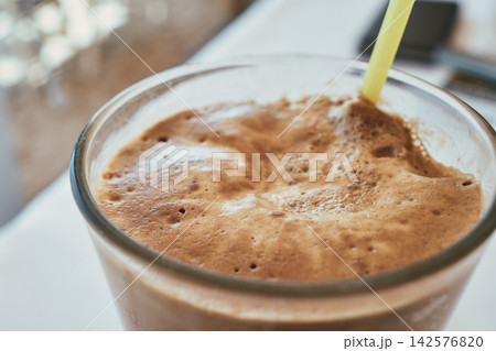 Close-up view of iced frappe coffee with thick creamy foam and yellow straw Close-up view of iced frappe coffee with thick creamy foam and yellow straw 142576820
