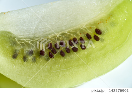 Macro close-up view of fresh green kiwi fruit flesh and tiny dark seeds 142576901