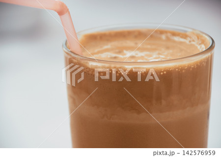 Close-up of a refreshing iced coffee frappe in a glass with a straw Close-up of a refreshing iced coffee frappe in a glass with a straw 142576959