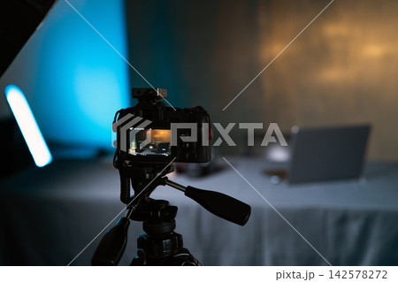 Professional DSLR camera on a tripod setup in a dark studio with blue led light shooting content  142578272
