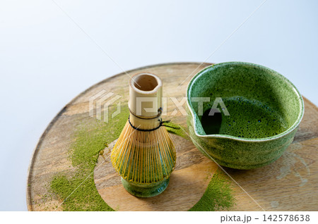 Minimalist Matcha Bowl and Whisk on Clean Background. Minimalist presentation of matcha bowl and bamboo whisk with soft studio lighting on clean background. Pastel tones and modern product styling wit 142578638