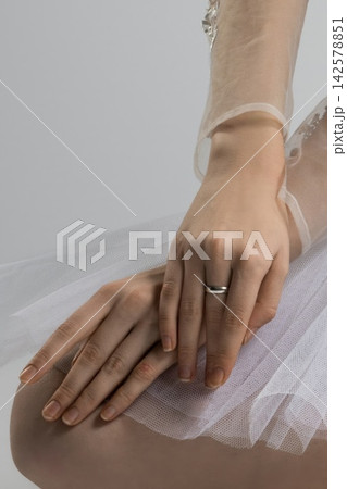 Ballerina's hands Resting on her knee wearing a Tutu and a simple Silver Ring 142578851
