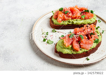 breakfast, Sandwiches with smoked salmon and avocado, on dark rye bread, with microgreens, on a marble table, homemade, no people, 142579022