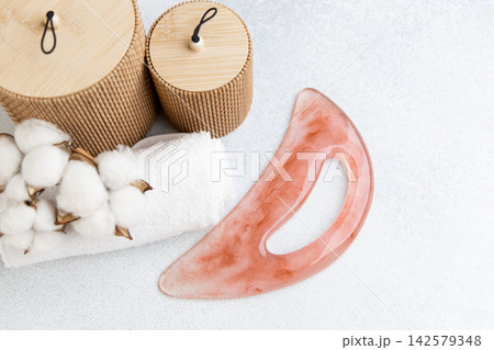 Anti-cellulite guasha massager with tools and natural elements on a surface in a spa setting Anti-cellulite guasha massager with tools and natural elements on a surface in a spa setting 142579348