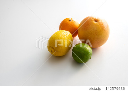 Minimal Still Life of Lemon Lime and Grapefruit. A ripe lemon, lime and pink grapefruit arranged on a bright white surface, a simple minimal still life of fresh citrus fruit rich in vitamin C for heal 142579686