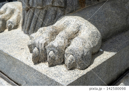 Stone lion paw sculpture in bright sunlight outdoors 142580098