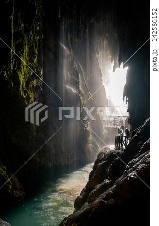 Inside the Mysterious Iris Grotto. Inside the mysterious Iris grotto with light streaming through its opening behind a waterfall in the Monasterio de Piedra natural park in Aragon, Spain, an atmospher 142580152
