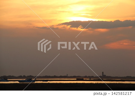 Venetian Lagoon sunset with pink clouds and water reflection Venetian Lagoon sunset with pink clouds and water reflection 142581217