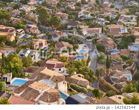 relaxed suburban residential neighborhood with houses, swimming pools, palm trees, solar panels, and brick, concrete, metal materials in brown, white, blue, green colors. 142582544