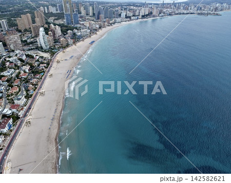 tranquil beach scene with urban coastal cityscape and aerial view of buildings, sand, and water in blue and gray tones, featuring serene and dynamic elements for real estate and travel. tranquil beach scene with urban coastal cityscape and aerial view of buildings, sand, and water in blue and gray tones, featuring serene and dynamic elements for real estate and travel. 142582621