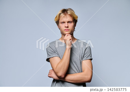 Portrait of thoughtful teenage boy touching chin Portrait of thoughtful teenage boy touching chin 142583775