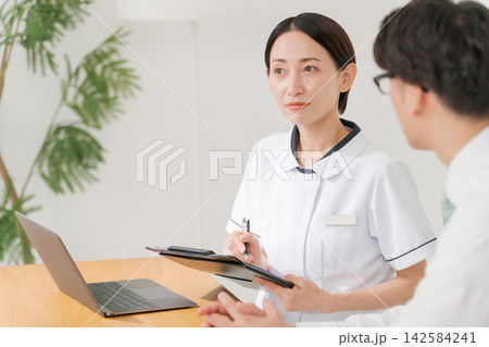 クリニックの女性スタッフと男性客 142584241