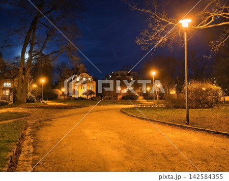 Serene residential street with gentle curves and soft lighting ideal for nighttime activities 142584355