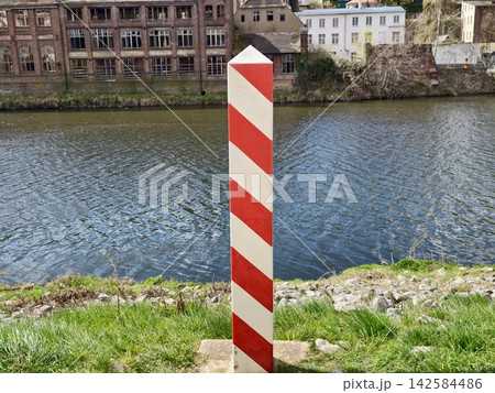 Sign along peaceful waterway with structures. Urban rural transition depicted by signs and scenery Sign along peaceful waterway with structures. Urban rural transition depicted by signs and scenery 142584486