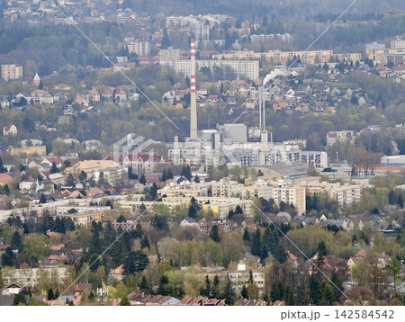 Factories and smokestacks near homes. Industrial emissions and urban landscape interweave visibly 142584542