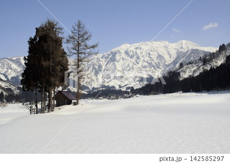 雪原と山並みに寄り添う山小屋が描く冬の静景 142585297
