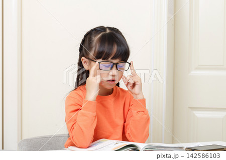 Tired Asian schoolgirl rubbing eyes with glasses, eye strain and study fatigue concept Tired Asian schoolgirl rubbing eyes with glasses, eye strain and study fatigue concept 142586103