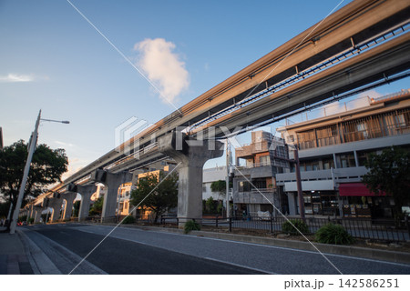 天気の良い沖縄のモノレールのゆいレールの線路と道路沿いに並ぶ建物 天気の良い沖縄のモノレールのゆいレールの線路と道路沿いに並ぶ建物 142586251