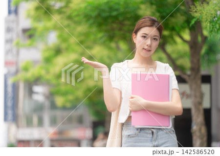 街中で指差しする若い女性　学生 142586520