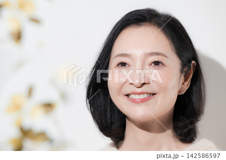 秋の前ボケとニットと笑顔を見せる50代女性透明感とツヤと保湿、ハリのあるビューティー 秋の前ボケとニットと笑顔を見せる50代女性透明感とツヤと保湿、ハリのあるビューティー 142586597