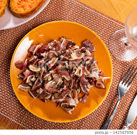 Pieces of pickled and boiled pork ears perfectly complement glass of dark beer. Pieces of pickled and boiled pork ears perfectly complement glass of dark beer. 142587056