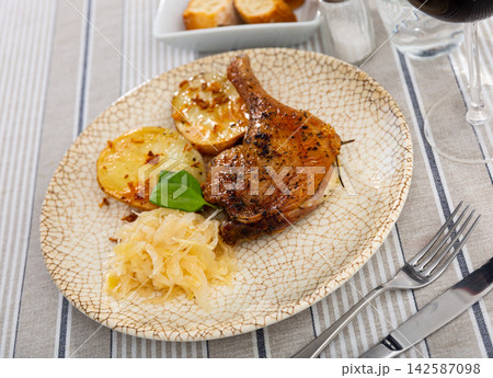 Roast duck leg with potatoes and cabbage on a ceramic plate Roast duck leg with potatoes and cabbage on a ceramic plate 142587098