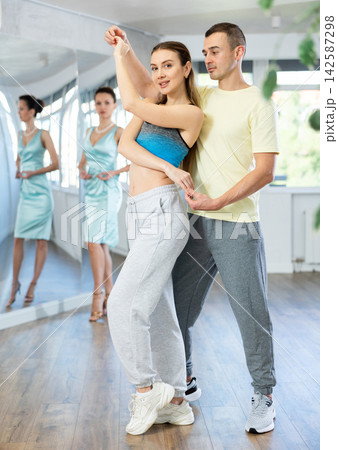 Positive man and woman practicing samba in dance class Positive man and woman practicing samba in dance class 142587298