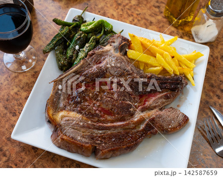 Fried beef served with potatoes and peppers 142587659