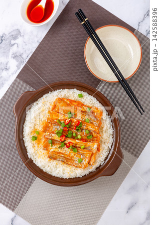 Chinese claypot rice topped with spicy braised ribbonfish fillets on marble background Chinese claypot rice topped with spicy braised ribbonfish fillets on marble background 142588396