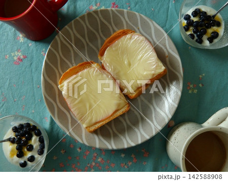 おしゃれな朝食テーブル：チーズトーストとヨーグルト、コーヒーの俯瞰カット 142588908