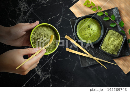 Matcha. Hands mix matcha powder in bowl using bamboo whisk. Matcha preparation concept Matcha. Hands mix matcha powder in bowl using bamboo whisk. Matcha preparation concept 142589748