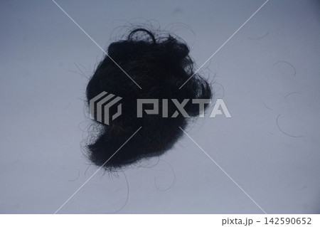 Tangled clump of black human hair isolated on neutral background Tangled clump of black human hair isolated on neutral background 142590652