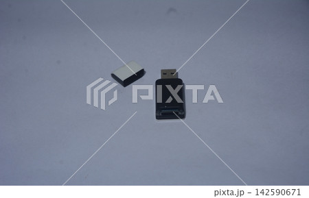 A top-down studio photo of a black plastic USB flash drive with its cap resting beside it A top-down studio photo of a black plastic USB flash drive with its cap resting beside it 142590671