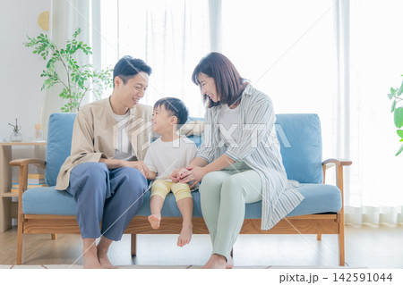 リビングで団らんする若い家族 リビングで団らんする若い家族 142591044