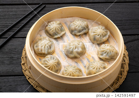 chinese steamed vegetable buns with thin wrapper inside a traditional bamboo steamer. chinese steamed vegetable buns with thin wrapper inside a traditional bamboo steamer. 142591497