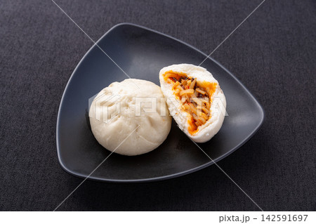 steamed hot and sour shredded potato buns cut open on black plate, Chinese savory baozi 142591697